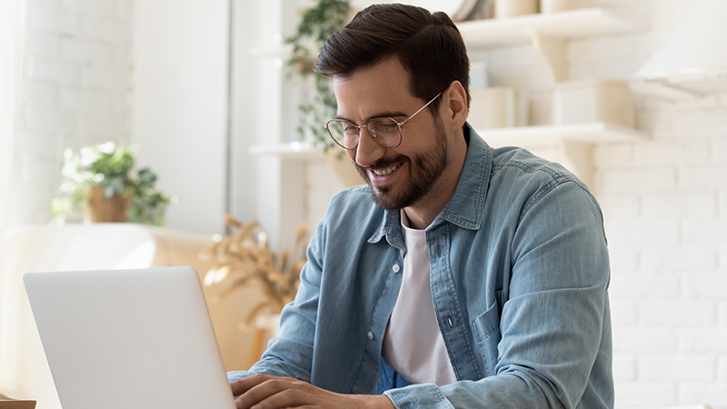 man using laptop and smiling