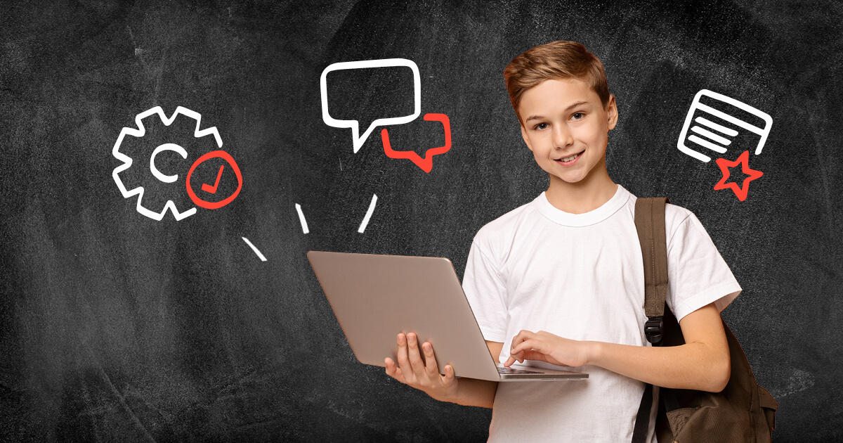 School child uses laptop in front of chalkboard