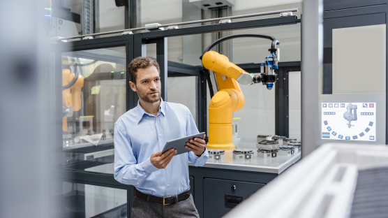 man stands in hi tech manufacturing environment