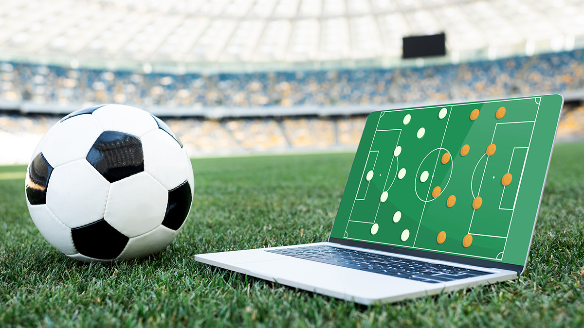 football and laptop on pitch