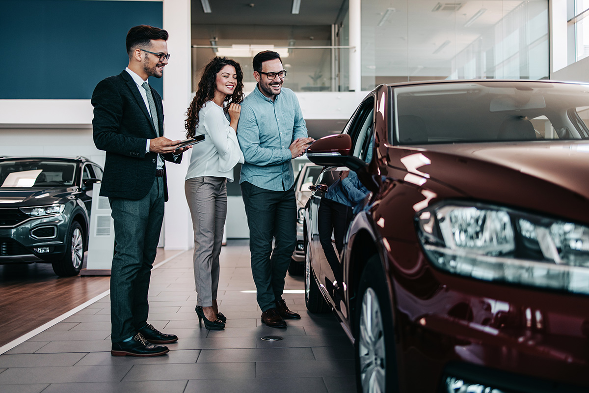 couple shown around car dealership